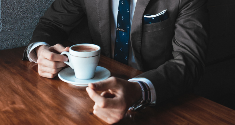 Man in a suit seated with coffee for private conversation
